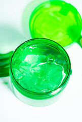 Fresh Aloe Vera Gel Into Green Jar Isolated On White
