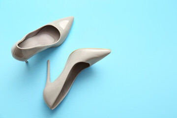 Stylish high heeled shoes on light blue background