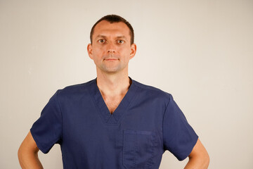 In dark blue medical clothing, the man poses for a detailed photo. His focused gaze radiates professionalism and authority. The image emphasizes care, commitment, and expertise.