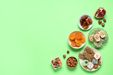 Composition with different Eastern sweets for Ramadan celebration on green background
