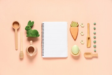 Composition with blank notebook for recipes, kitchen utensils, Easter decor and treats on color background