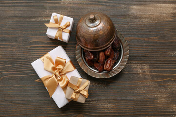 Dates and gift boxes on wooden background. Ramadan celebration