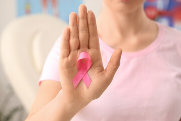 Fototapeta premium Young woman with pink ribbon in clinic, closeup. Breast cancer awareness concept