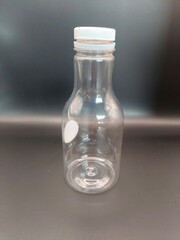 Empty clear plastic bottle with a white cap, ideal for storing beverages or DIY projects. Simple, reusable, and eco-friendly!