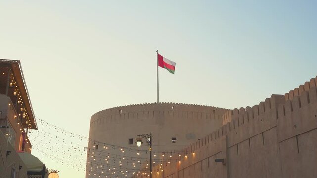 Medium-shot of Oman flag on top of Nizwa fort