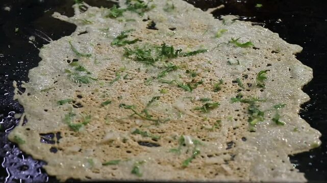 Cocinando queso a la plancha con cilantro y cebolla para preparar chicharr&oacute;n de queso