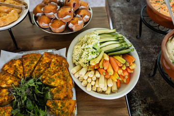 overhead shot of brunch buffet with quiche, muffins and raw veggies mix