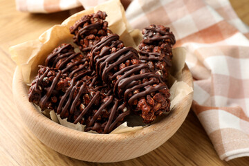 Delicious chocolate puffed rice bars on wooden table, closeup