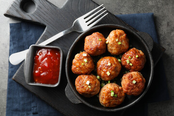 Tasty meatballs served on grey table, flat lay