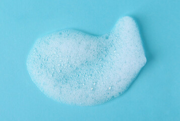 Sample of fluffy foam on light blue background, top view