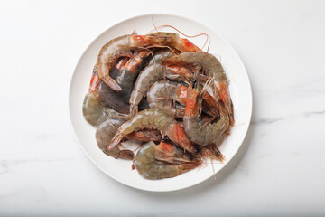 Fresh raw shrimps on white marble table, top view