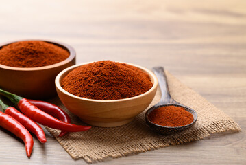 Red chili powder in bowl on wooden background, Food seasoning