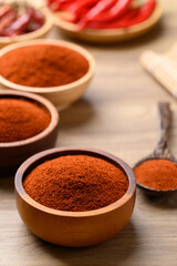 Red chili powder in bowl on wooden background, Food seasoning