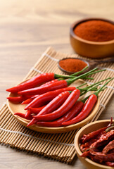 Fresh red chili peppers and chili powder on wooden background, Food ingredient