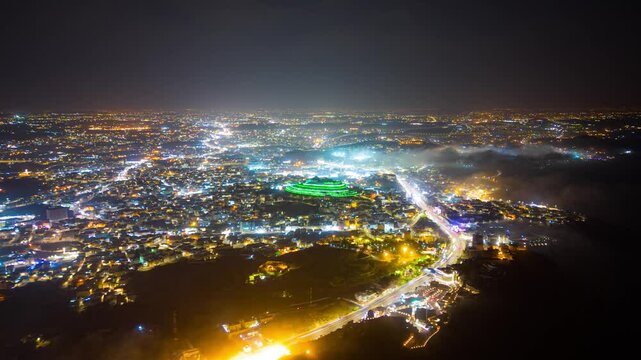 Abha City at night, drone aerial hyperlapse showing the Green Mountain and other spots in the city covered by moving clouds and fog, Saudi Arabia