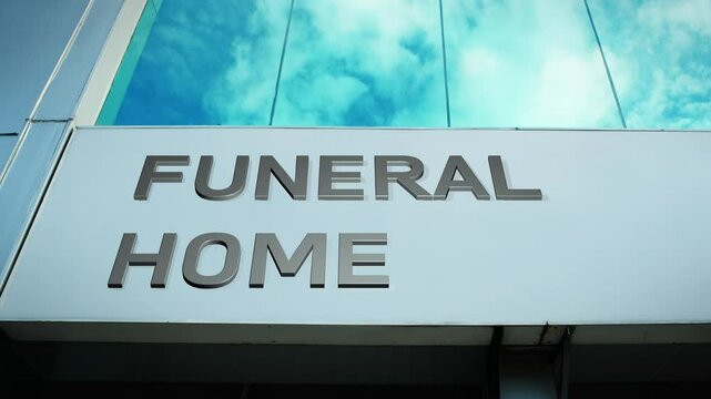 Funeral home sign on a modern building with glass windows, symbolizing services, remembrance, and peace