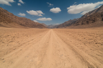 Naklejka premium A road in the desert with a clear blue sky above