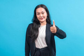 Asian woman with long black hair wearing a black cardigan and white shirt, showing a thumbs-up...