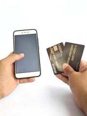 Hands holding a cell phone and credit card