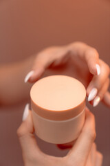 Hand-Held BB Cream Beauty Product Box on a Vibrant Orange Background