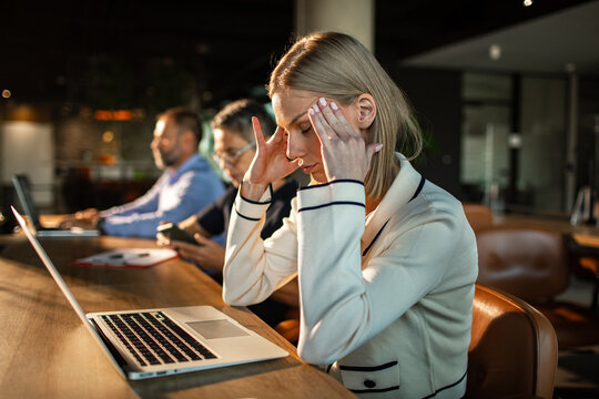Stressed businesswoman at work holding head in frustration