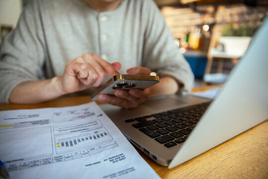 Stressed Asian woman struggling with finances and bills at home with laptop