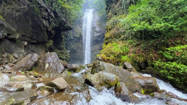 Holy waterfall of Abkhazia on a cloudy winter day in the mountains of the Caucasus. Mountain cascade waterfall. Eastern Abkhazia. Not far from the town of Tkvarcheli. Akarmara district.