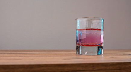 Layered drink in a modern glass. Ideal for cocktail recipes or social media content. Invites viewers to indulge in a refreshing experience.