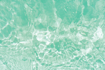 Blue water with ripples on the surface. Defocus blurred transparent blue colored clear calm water surface texture with splashes and bubbles. Water waves with shining pattern texture background.