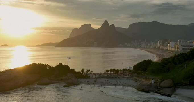 Flying backwards above the ocean and Arpoador, famous place for watching sunset in Rio de Janeiro, wide angle