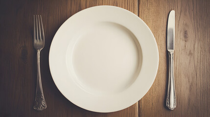 un plato vacio con cubiertos tenedor y cuchillo a los lados sobre una mesa de madera simplicidad y minimalismo 