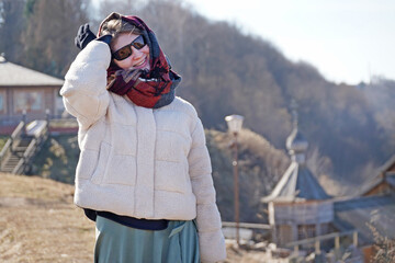 woman on the background of a wooden Christian church in spring