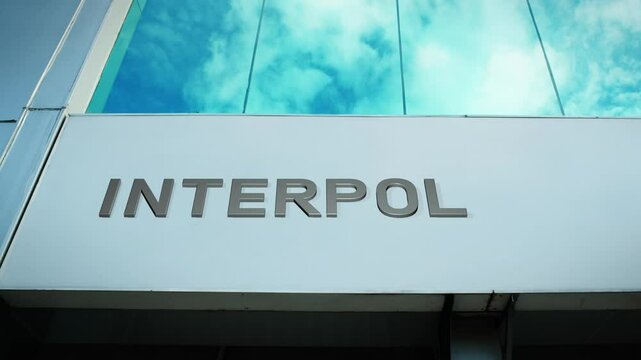 Interpol sign on a modern building with glass windows, symbolizing international cooperation, law enforcement, and security