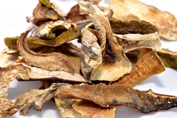 Sliced ​​dry pieces of porcini mushrooms lie on a white background