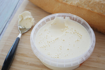 Creamy butter spread beside fresh crusty bread on wooden board