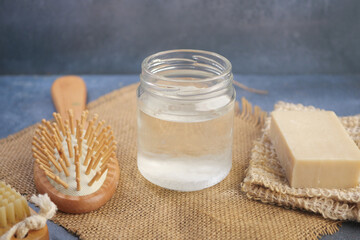 coconut oil and Natural hair care products arranged on a rustic table