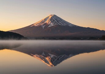 Fototapeta premium Symmetrical and peaceful landscape is captured by a majestic mountain with a snow-capped peak reflected in a misty lake at golden sunrise