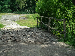 Old wooden exotic bridge over a ditch.
