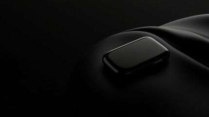 A sleek black smartphone rests on a black surface.