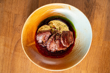 Tender cuts of meat resting in a luscious sauce, beautifully paired with a creamy element and herbs