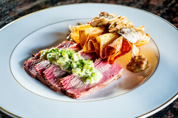 Tender beef, crispy potatoes, and a vibrant green sauce create a stunning dish