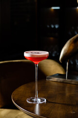A vibrant cocktail sits gracefully on a polished table, inviting relaxation in a cozy environment