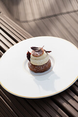 A beautifully crafted dessert sits on a pristine plate, showcasing layers and delicate details