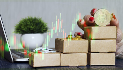 Cryptocurrency and precious metals investment workspace with bitcoin coin, candlestick chart overlay, gold bars on stacked cardboard boxes