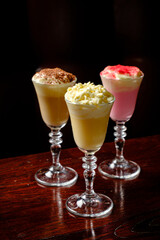 Three elegant dessert shots stand proudly on a wooden table, ready to be savored