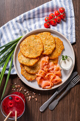 Enjoy a plate of crispy potato pancakes paired with delicate smoked salmon and vibrant garnishes