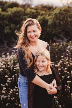 Mom and daughter smiling and looking to the right.