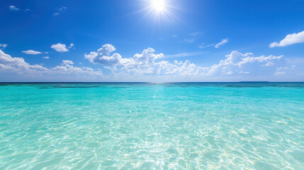 Fototapeta premium Clear Blue Ocean Water Under Bright Sunlight with Fluffy Clouds and Blue Sky