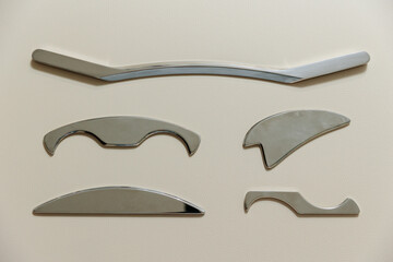 Intelligent stainless steel IASTM instruments for soft tissue massage and pain relief, the instruments lie on a beige massage table