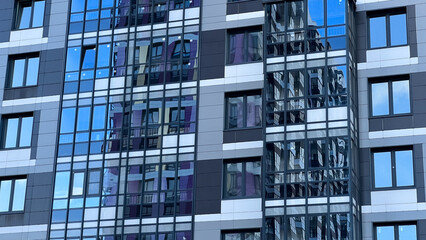 Modern facade of a new residential complex, blue glass facade glazing. Residential apartments or architecture of an office building